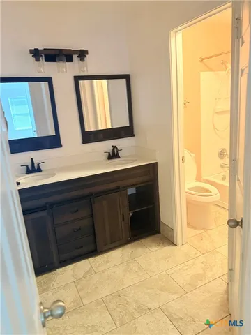 a bathroom with a tub sink and mirror