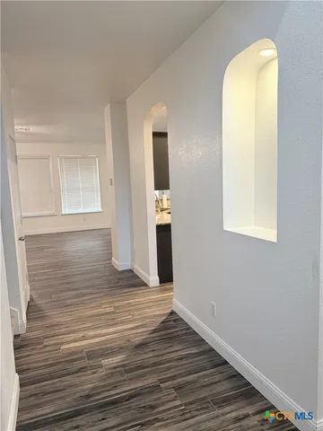 a view of a room with wooden floor and entryway