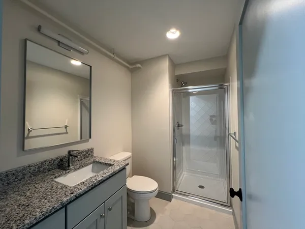 a bathroom with a granite countertop sink toilet and shower
