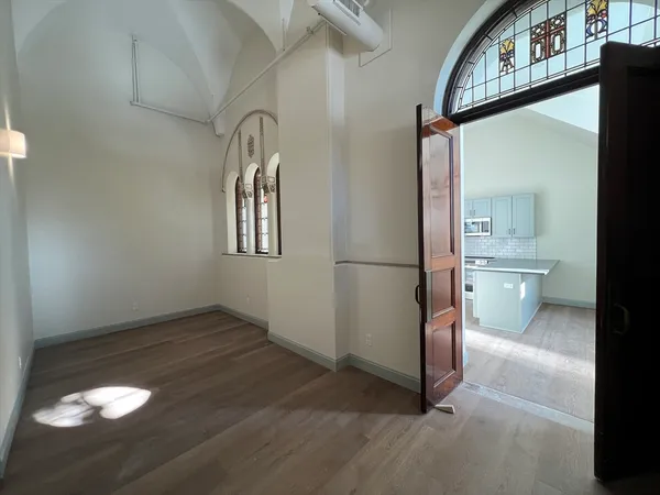 a view of an empty room with a fireplace and a window