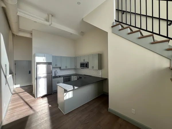 a kitchen with stainless steel appliances granite countertop a sink and a refrigerator