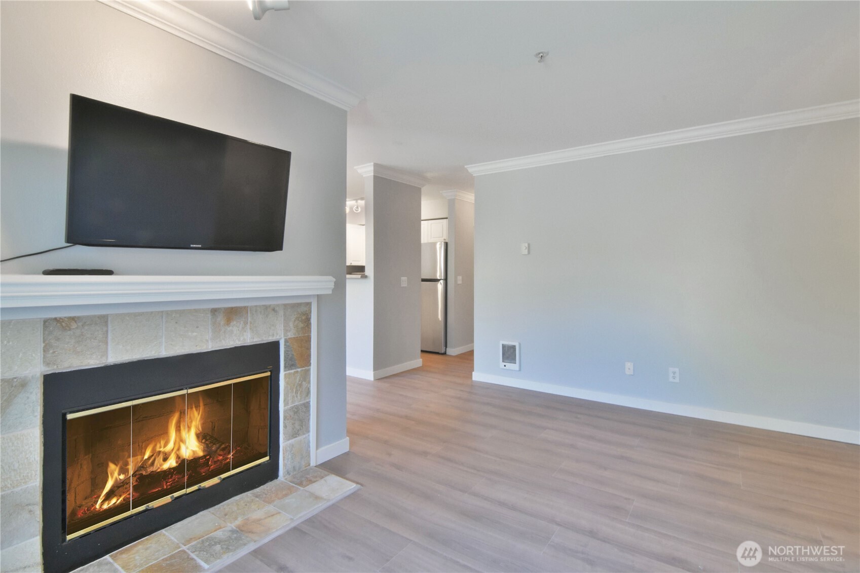 33020 10th Avenue Southwest, Unit Z203 Federal Way, WA 98023 - Photo 3 of 25 a living room with a fireplace a flat screen tv and a fireplace
