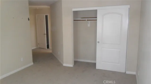 an empty room with closet and a hallway