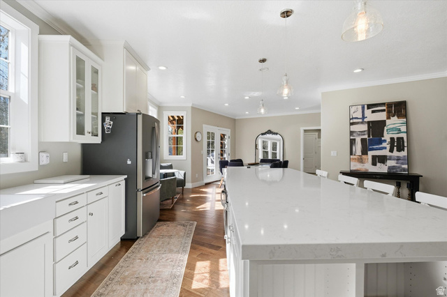 353 Robin Street Smithfield, UT 84335 - Photo 9 of 70 Kitchen featuring white cabinetry, light stone counters, a spacious island, a breakfast bar area, and pendant lighting