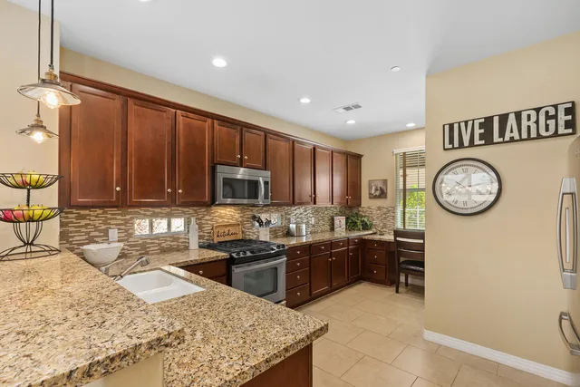 a kitchen with a sink stainless steel appliances and counter space