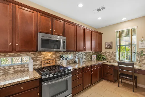 a kitchen with stainless steel appliances wooden cabinets and a stove top oven