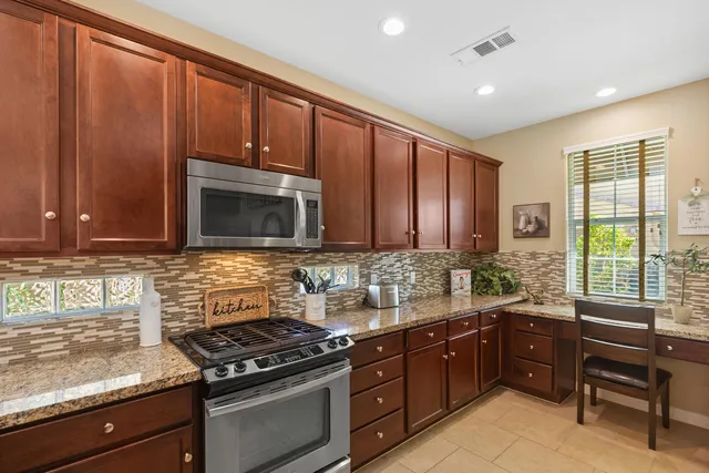 a kitchen with stainless steel appliances wooden cabinets and a stove top oven