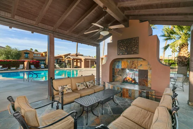 a patio with a table and chairs and a barbeque