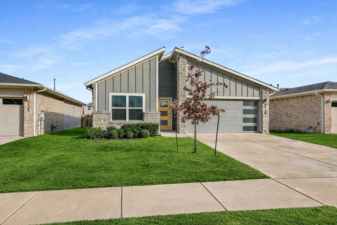 5125 Vanner Path Georgetown, TX 78626 - Photo 1 of 27 View of front facade featuring board and batten siding, a front lawn, driveway, and stone siding. Digitally Enhanced.