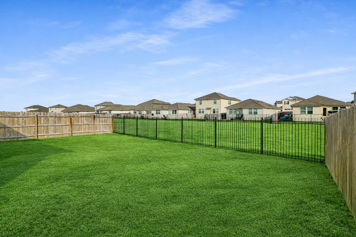 5125 Vanner Path Georgetown, TX 78626 - Photo 23 of 27 Fenced backyard featuring a residential view. Digitally Enhanced.