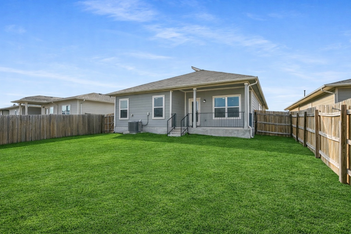 5125 Vanner Path Georgetown, TX 78626 - Photo 25 of 27 Rear view of house featuring a fenced backyard and a patio area. Digitally Enhanced.
