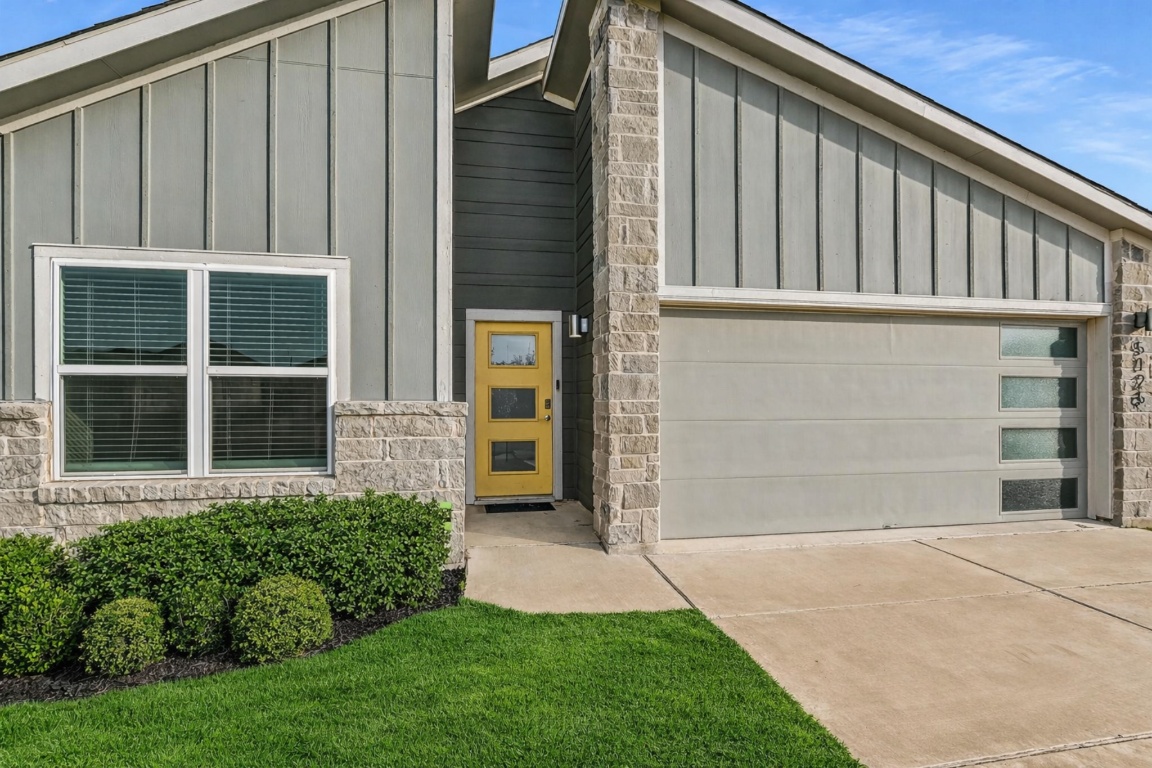 5125 Vanner Path Georgetown, TX 78626 - Photo 3 of 27 View of front of house featuring board and batten siding, stone siding, driveway, and a garage. Digitally Enhanced.