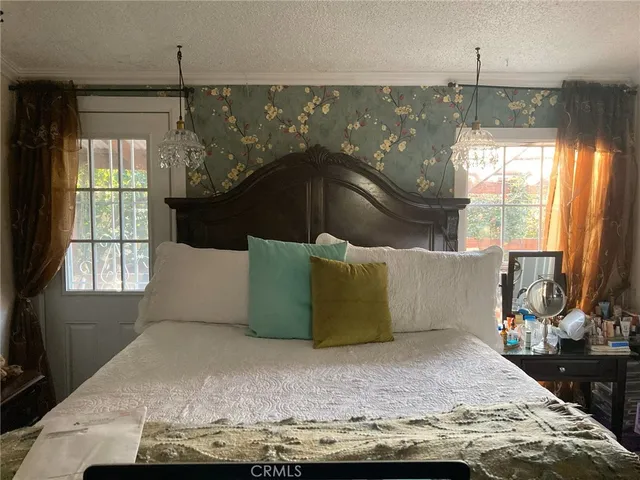 a large bed sitting in a bedroom next to a window