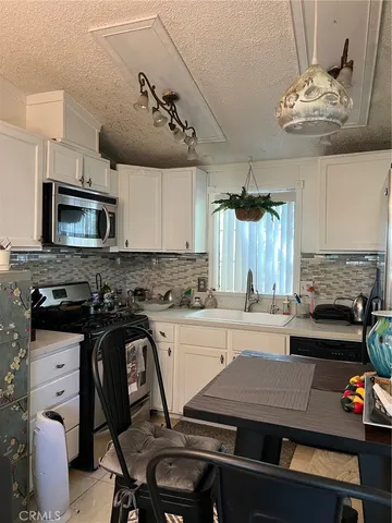 a kitchen with a table chairs a microwave and cabinets