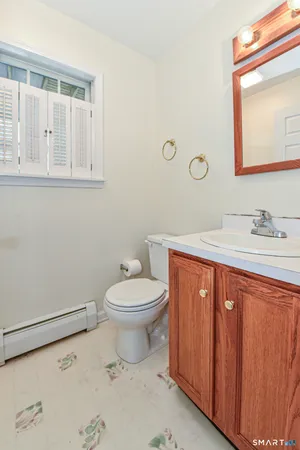 a bathroom with a toilet a sink and mirror