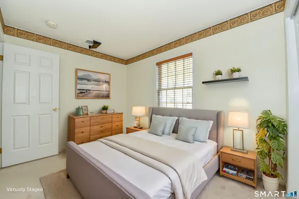 a bedroom with a bed and a potted plant