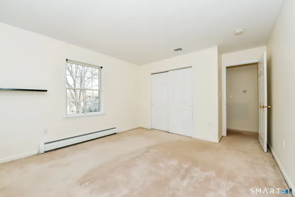 an empty room with windows and closet