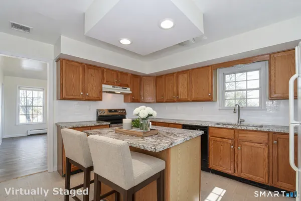 a kitchen with kitchen island granite countertop a sink and stove
