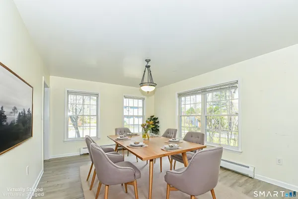 a dining room with furniture a chandelier and wooden floor