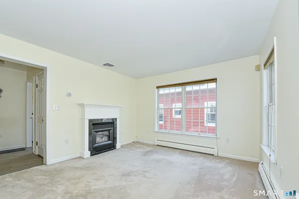 an empty room with fireplace and windows