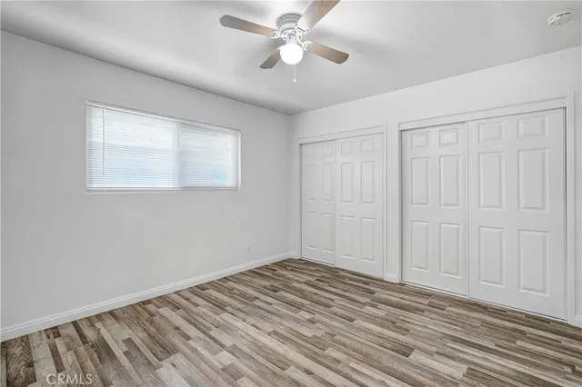 a view of a room with wooden floor and a ceiling fan