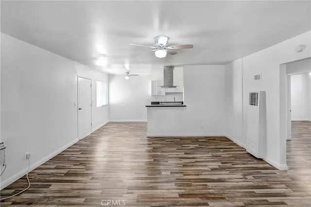 a view of a kitchen with wooden floor and a ceiling fan