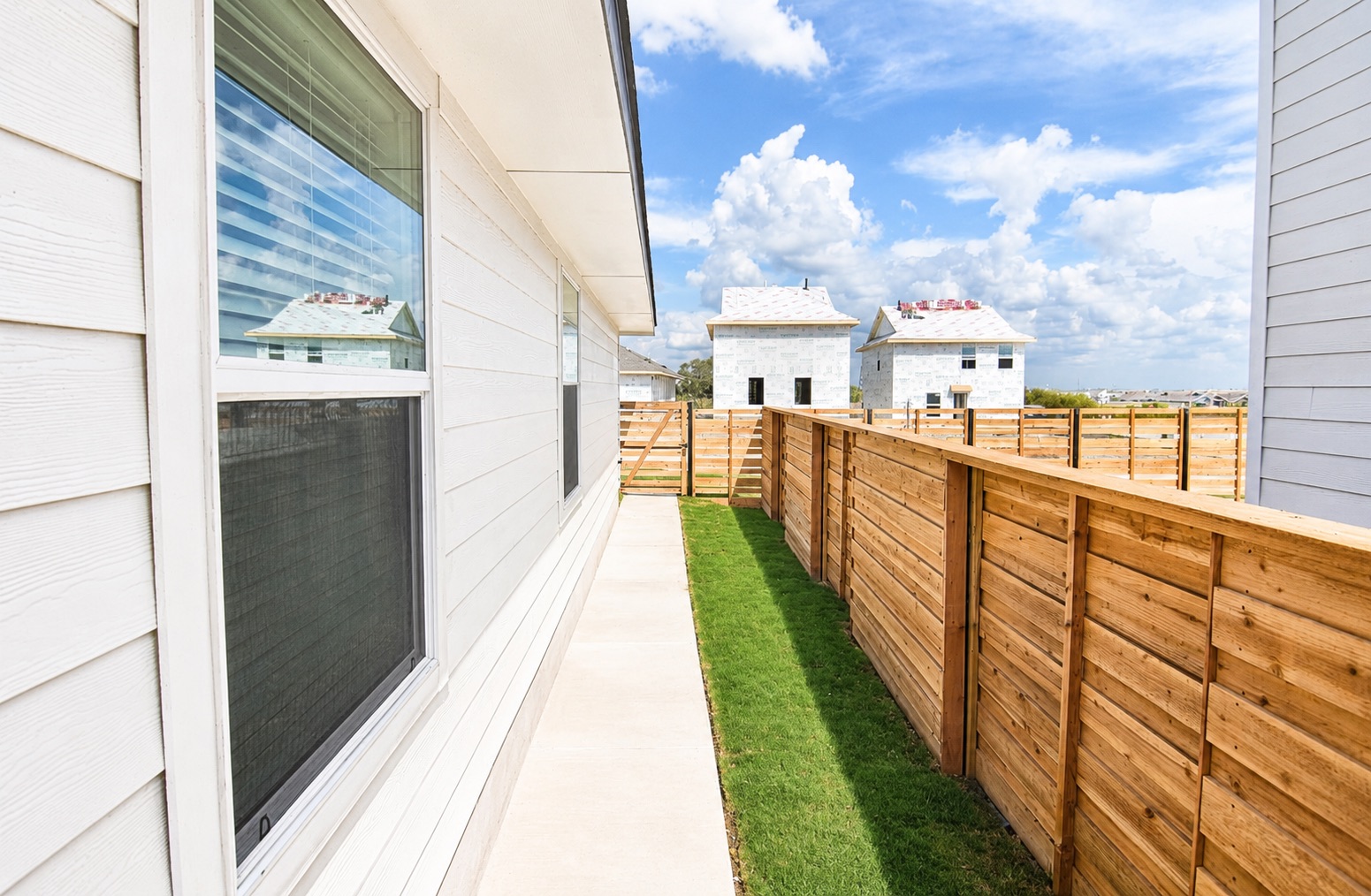 397 Keefer Kyle, TX 78640 - Photo 12 of 33 A newly installed wood fence borders a freshly sodded yard next to a crisp white-sided home.