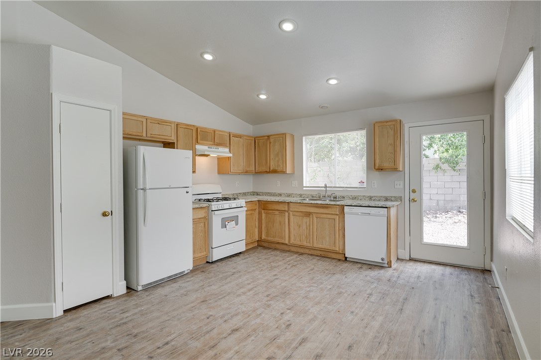 9660 Crystal Ridge Road Las Vegas, NV 89123 - Photo 3 of 13 A well-lit kitchen with natural wood cabinets, ample counter space, and integrated appliances.