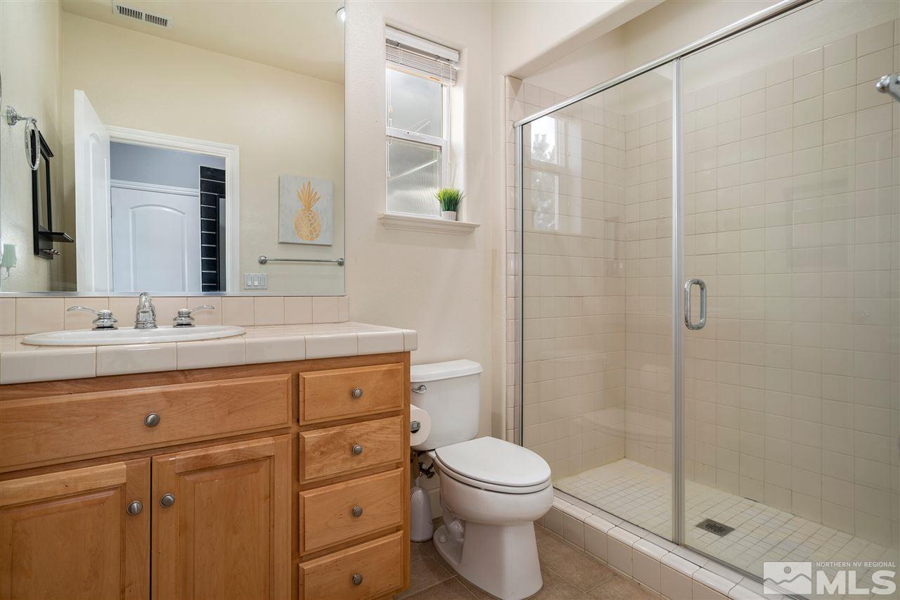 8475 Fairway Chase Trail Reno, NV 89523 - Photo 22 of 40 a bathroom with a shower sink vanity mirror and toilet