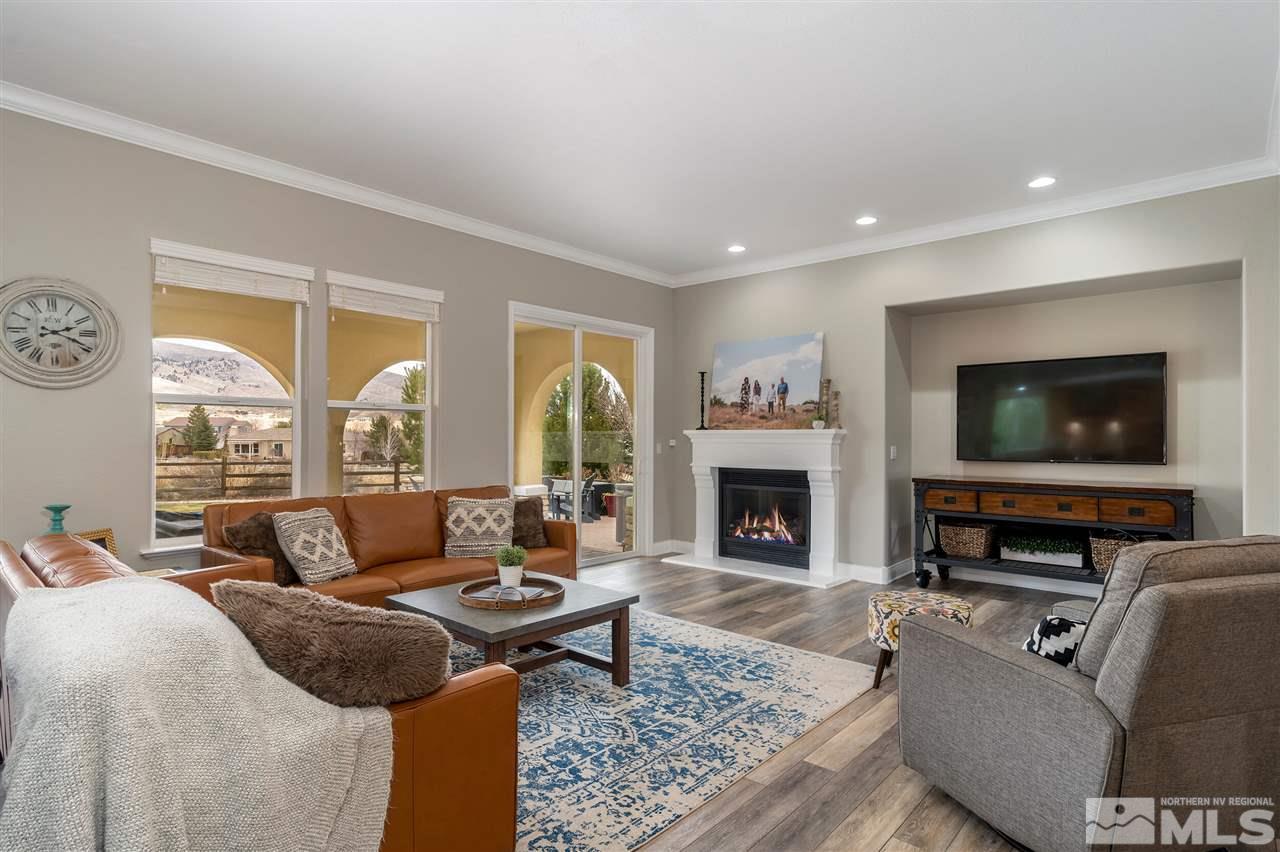 8475 Fairway Chase Trail Reno, NV 89523 - Photo 3 of 40 a living room with furniture a flat screen tv and a fireplace
