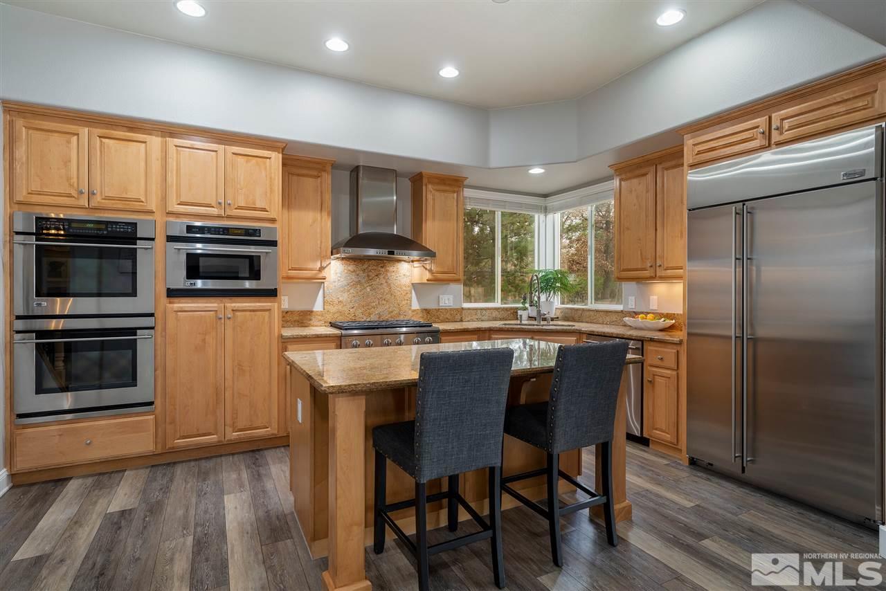 8475 Fairway Chase Trail Reno, NV 89523 - Photo 8 of 40 a kitchen with kitchen island granite countertop wooden cabinets and stainless steel appliances