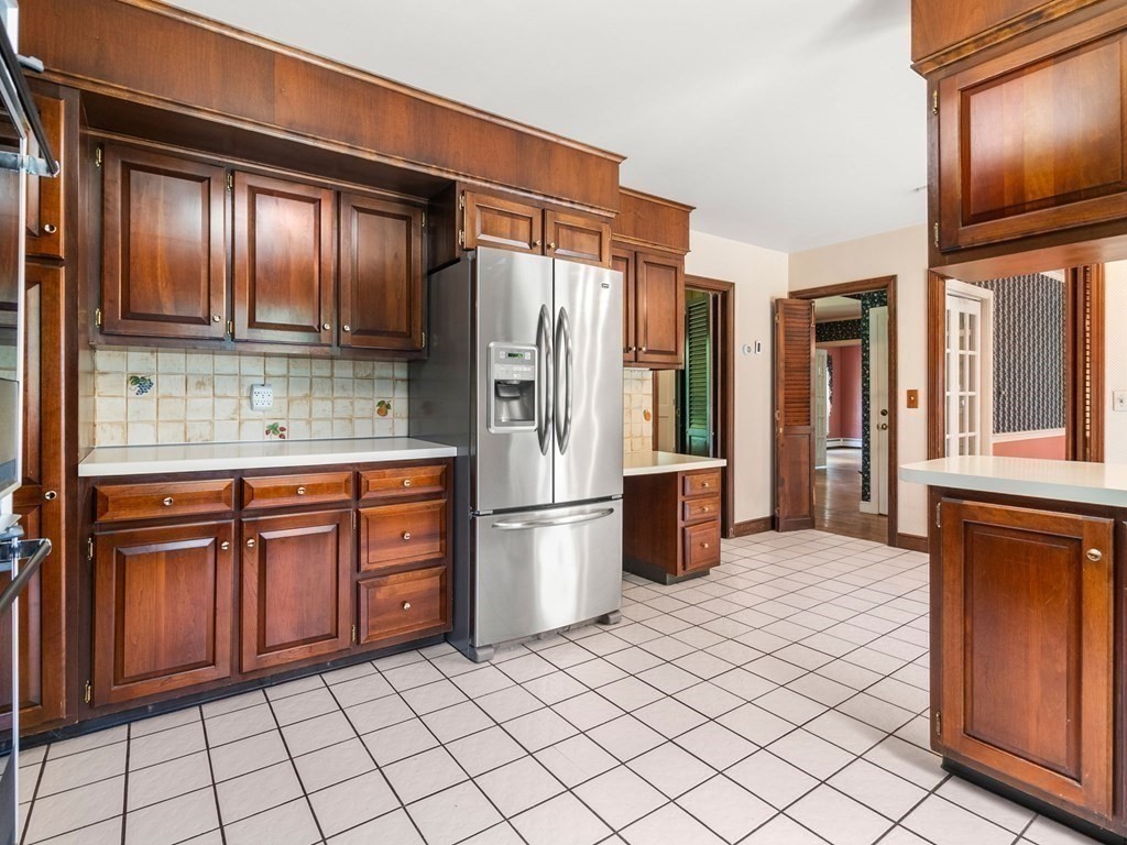 59 Spywood Road Sherborn, MA 01770 - Photo 9 of 40 a kitchen with stainless steel appliances granite countertop a refrigerator and wooden cabinets
