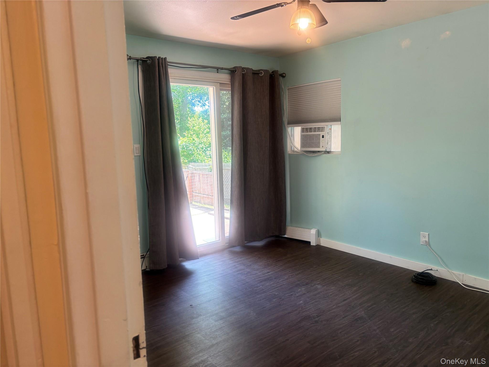 Undisclosed Address Shirley, NY 11967 - Photo 6 of 6 an empty room with wooden floor and windows