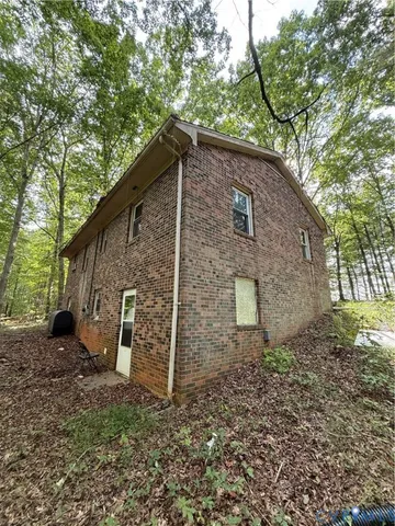 a backyard of a house with lots of tall trees