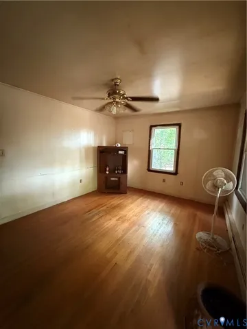 an empty room with windows and ceiling fan