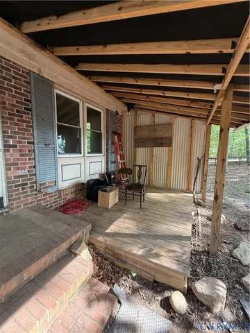 a view of a porch with furniture and floor to ceiling window