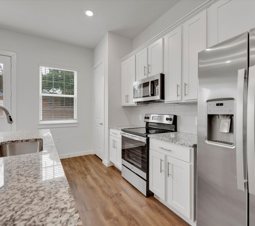 2703-107 Rockhill Road McKinney, TX 75072 - Photo 12 of 31 a kitchen with stainless steel appliances granite countertop a stove a sink and a refrigerator