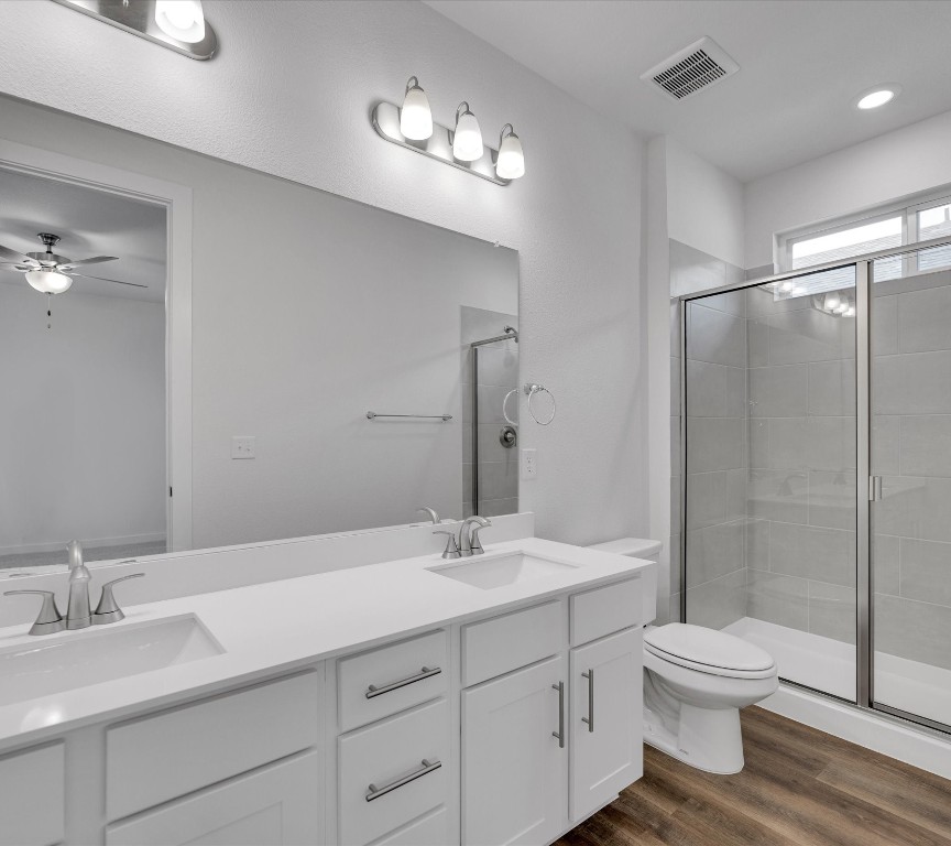 2703-107 Rockhill Road McKinney, TX 75072 - Photo 18 of 31 a bathroom with a granite countertop sink toilet a large mirror a shower and vanity