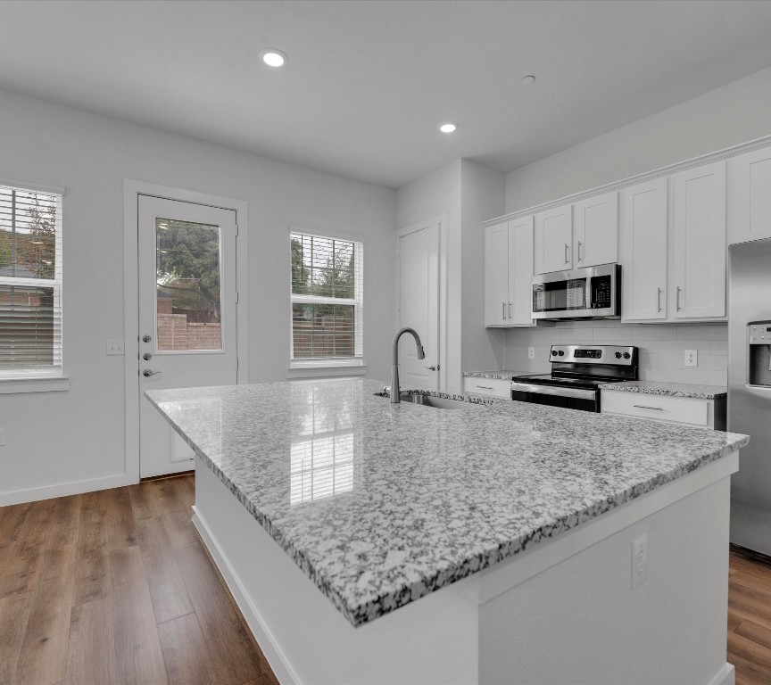 2703-107 Rockhill Road McKinney, TX 75072 - Photo 9 of 31 a kitchen with granite countertop a sink a counter top space appliances and cabinets