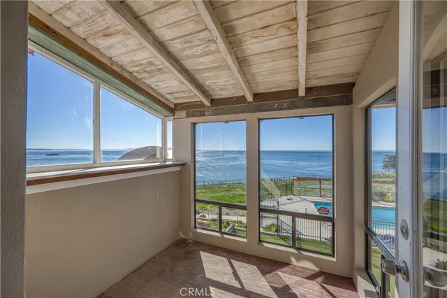 a view of a hallway with wooden floor and a chandelier