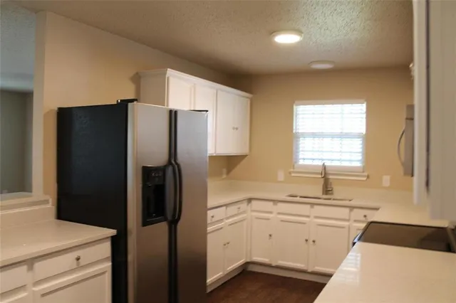a kitchen with white cabinets and white appliances