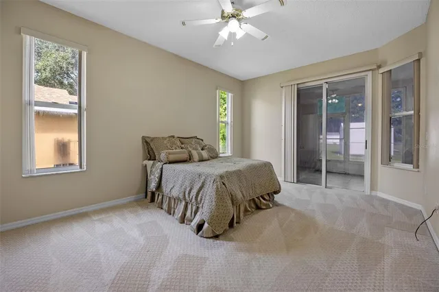 a spacious bedroom with a bed and glass window
