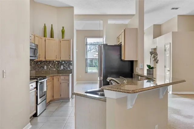 a kitchen with stainless steel appliances granite countertop a refrigerator and a stove
