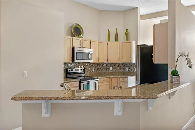 a kitchen with stainless steel appliances granite countertop a sink and a refrigerator