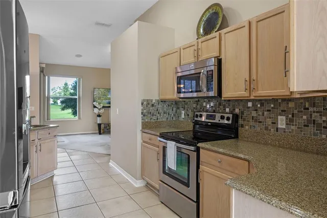 a kitchen with granite countertop a stove a sink and a microwave