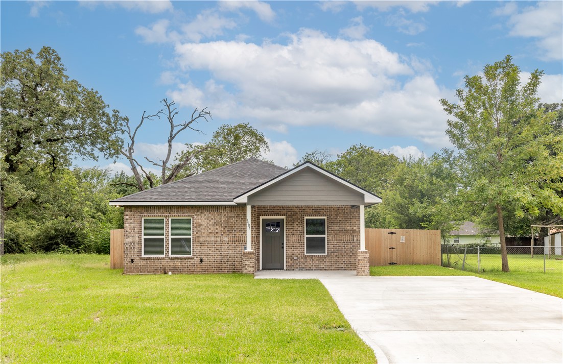 View of front of home with brick siding, concrete driveway, and a shingled roof