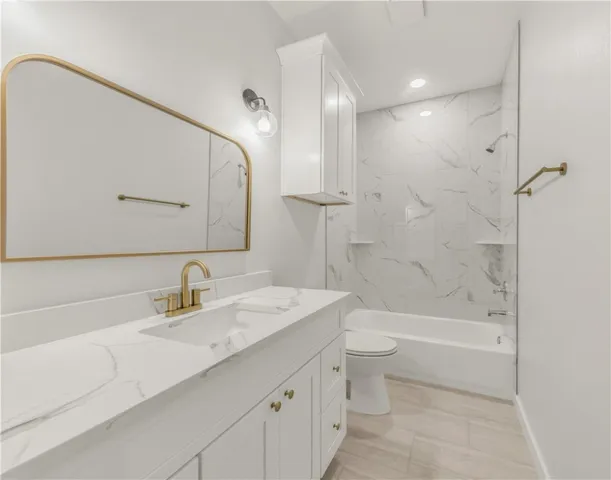 a bathroom with a sink a toilet and a large mirror