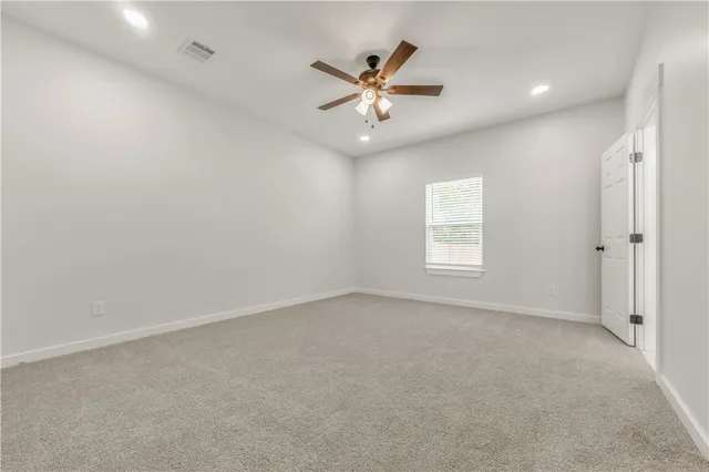 an empty room with window and ceiling fan
