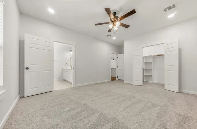 an empty room with closet and windows