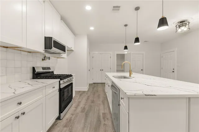 a kitchen with stainless steel appliances a stove a sink and a refrigerator